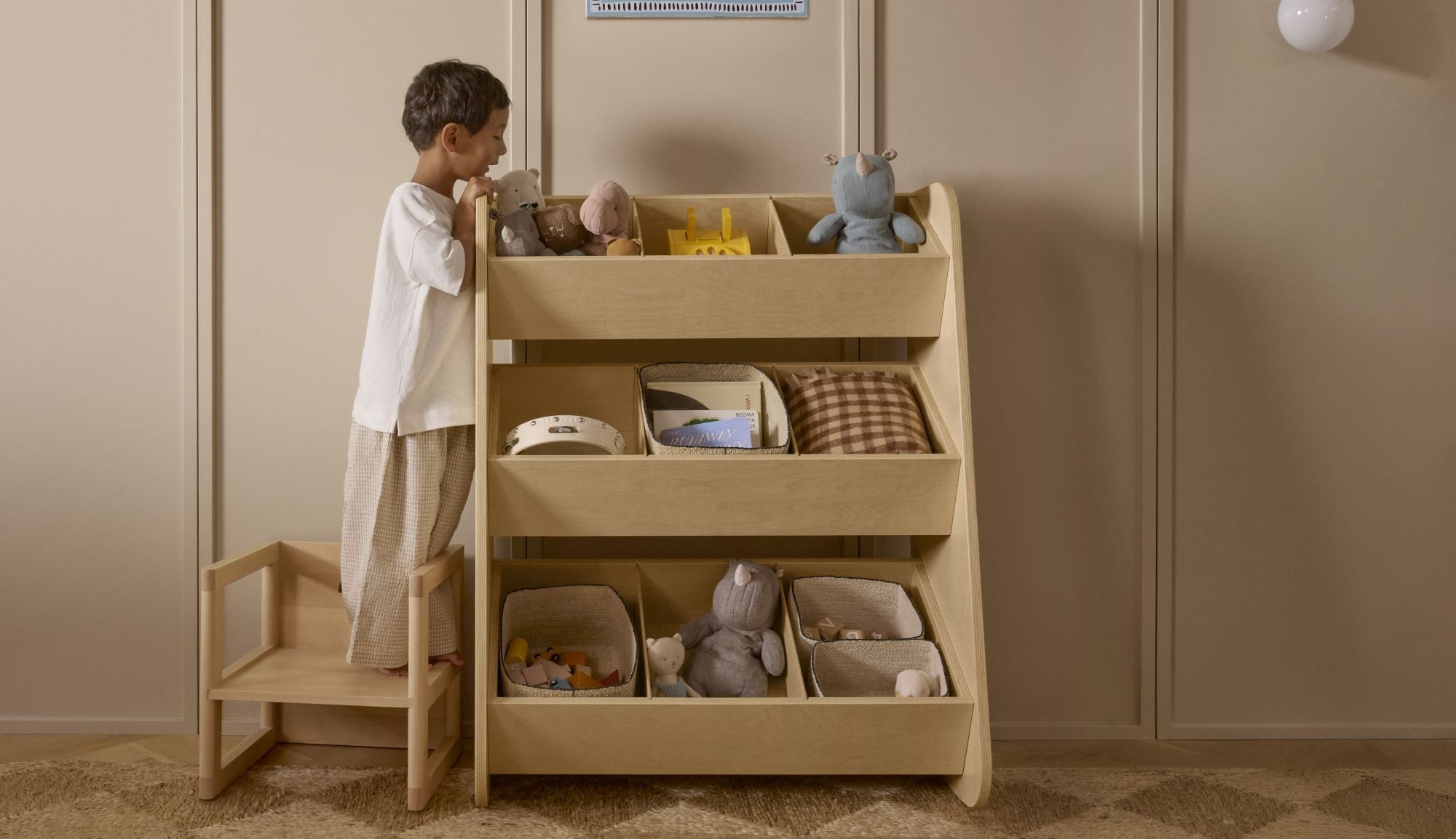 child reaching for toys on toy organizer, toy organizer bins, playroom storage