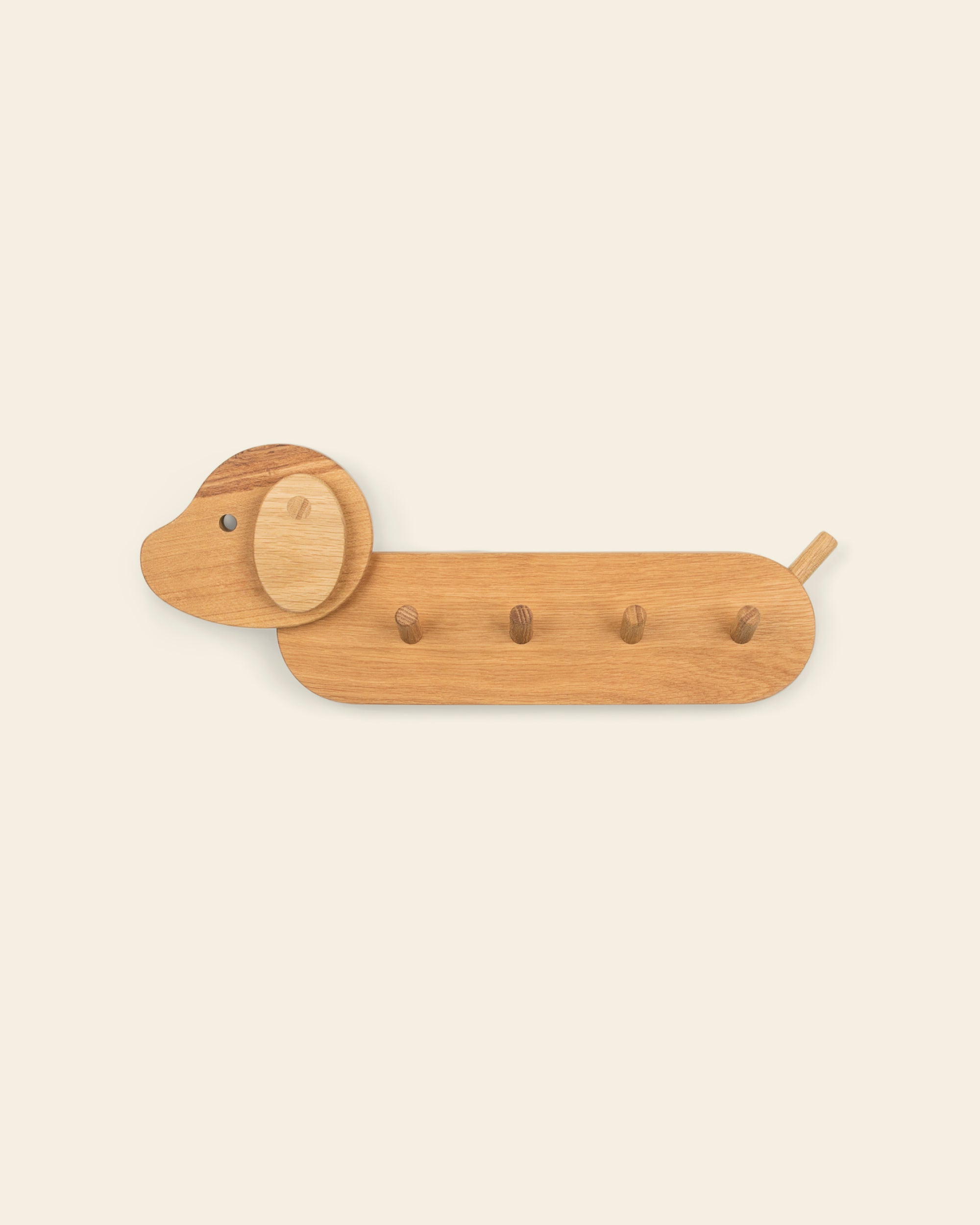 Close up of the dog style Piccalio Coat Rack for children made of natural oak wood and featuring four coat hooks