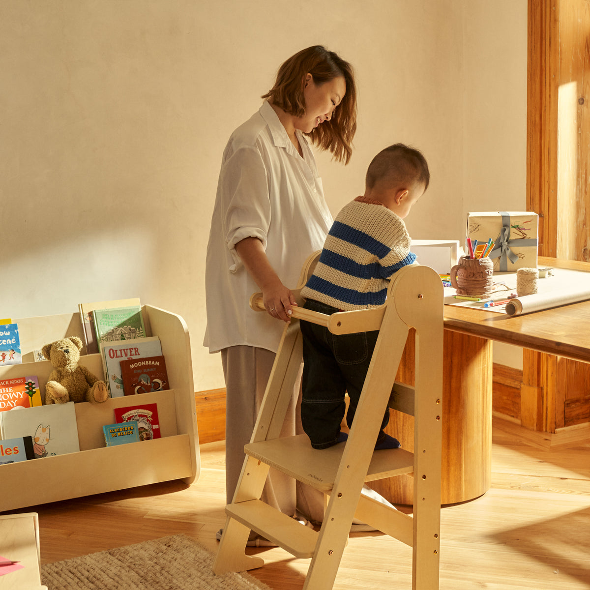 Child using the Piccalio Toddler Tower to wrap Christmas gifts