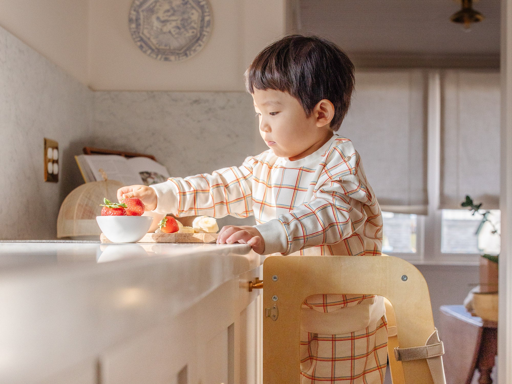 boy helping in the kitchen on the convertible learning tower helper stool