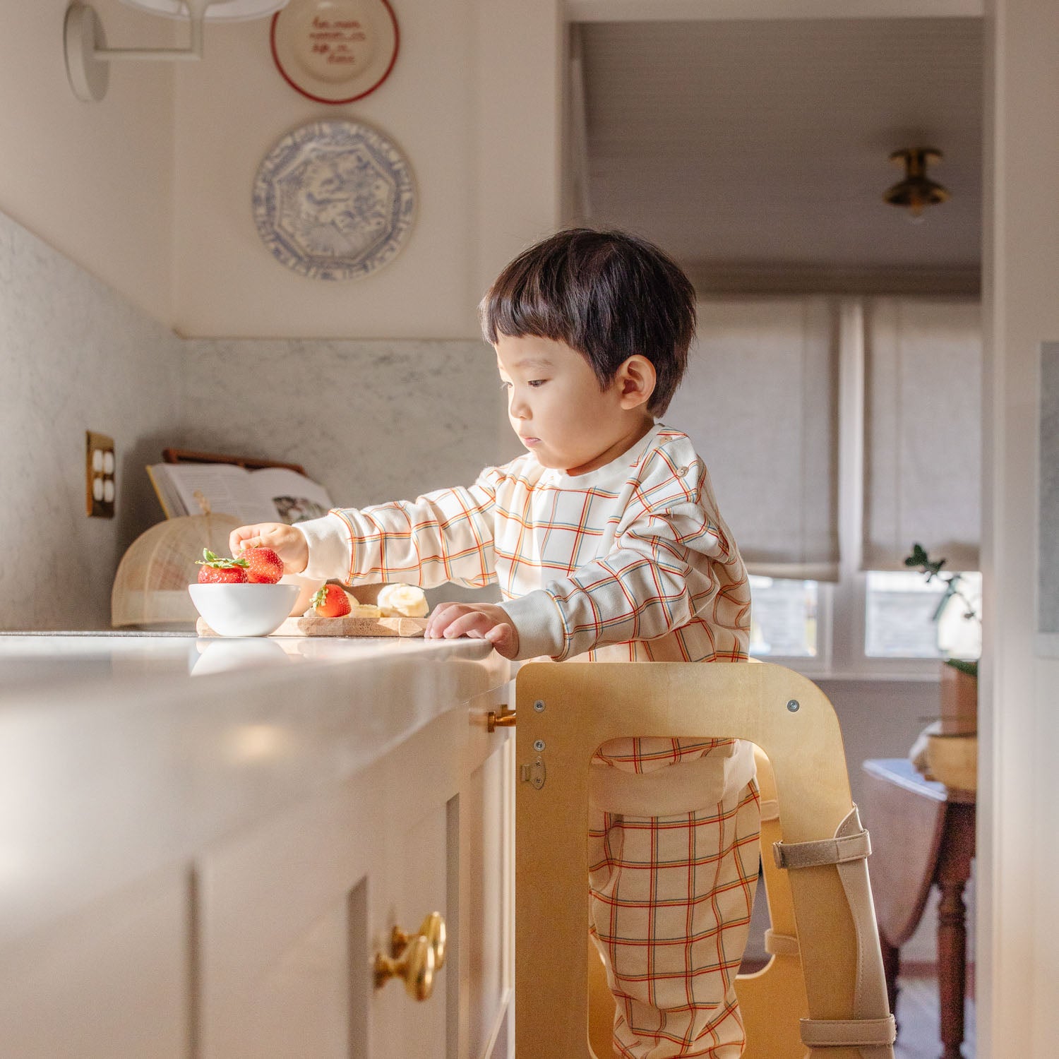 boy helping in the kitchen on the convertible learning tower helper stool