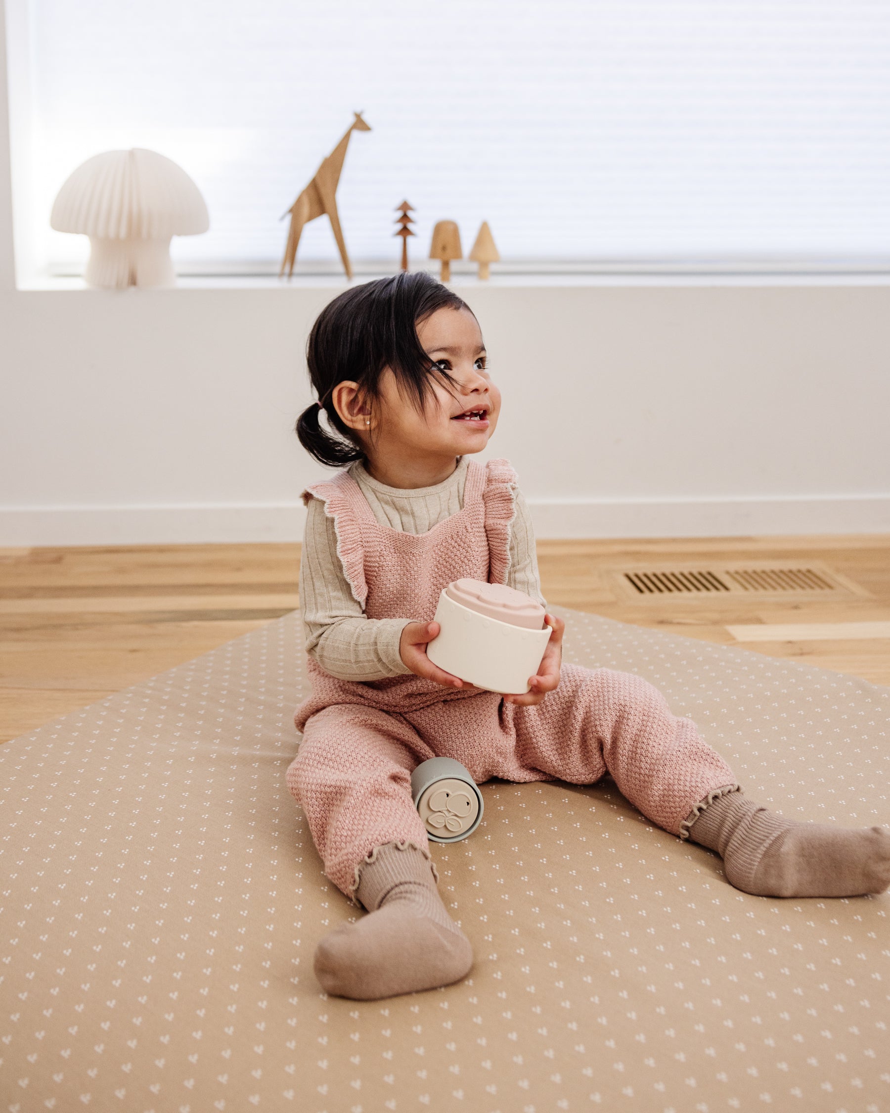 toddler playing with toys on play mat