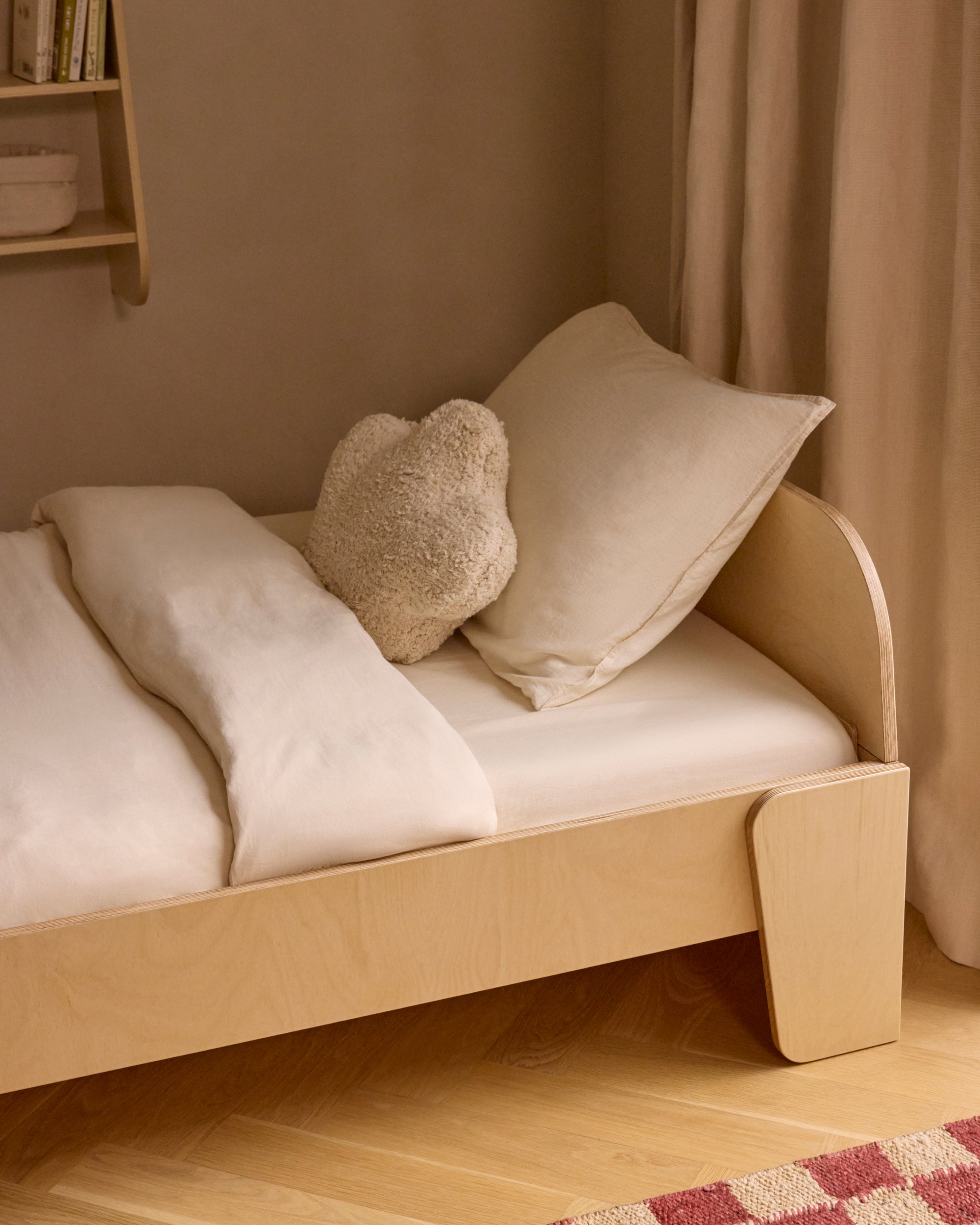 Piccalio Montessori floor bed in natural wood in a kids bedroom.