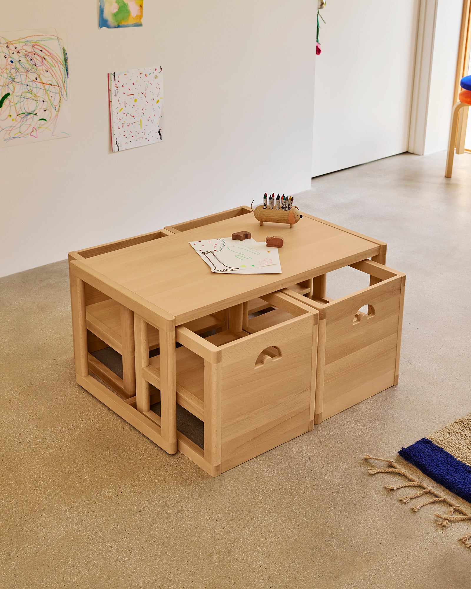Large Piccalio Montessori weaning table and 4 chairs nested for space-saving playroom storage.