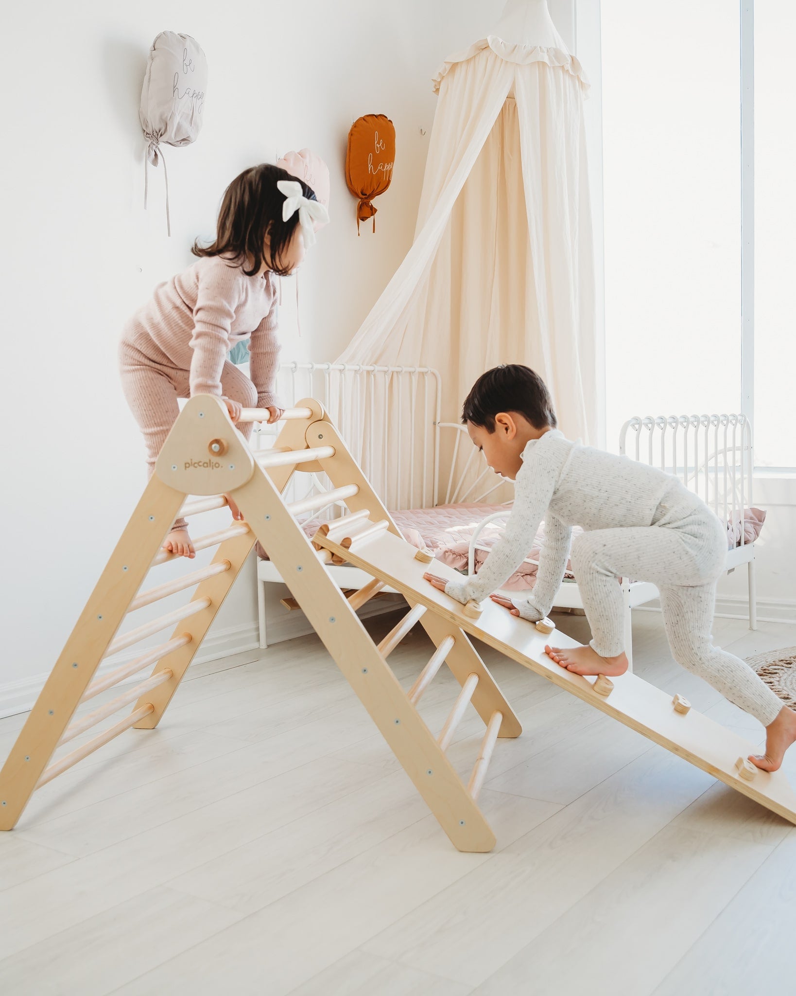 Piccalio Pikler Triangle in natural wood with two young children playing and building gross motor skills.