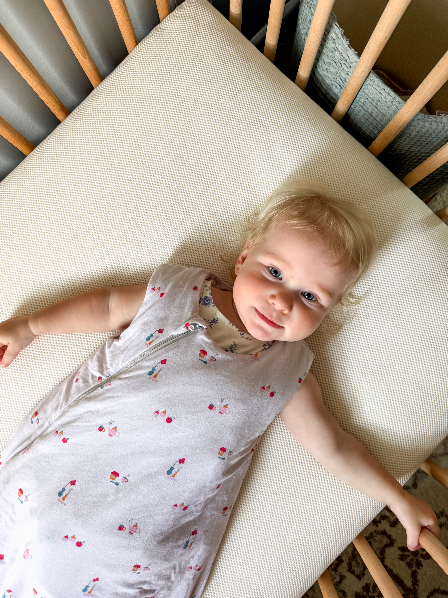 Toddler lying on a toddler bed mattress in a crib