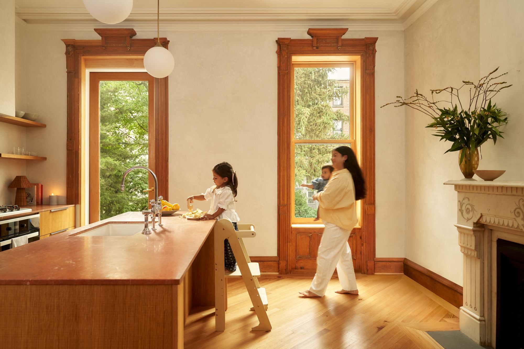 Child making a snack or meal using a Piccalio toddler tower in a bright, modern kitchen