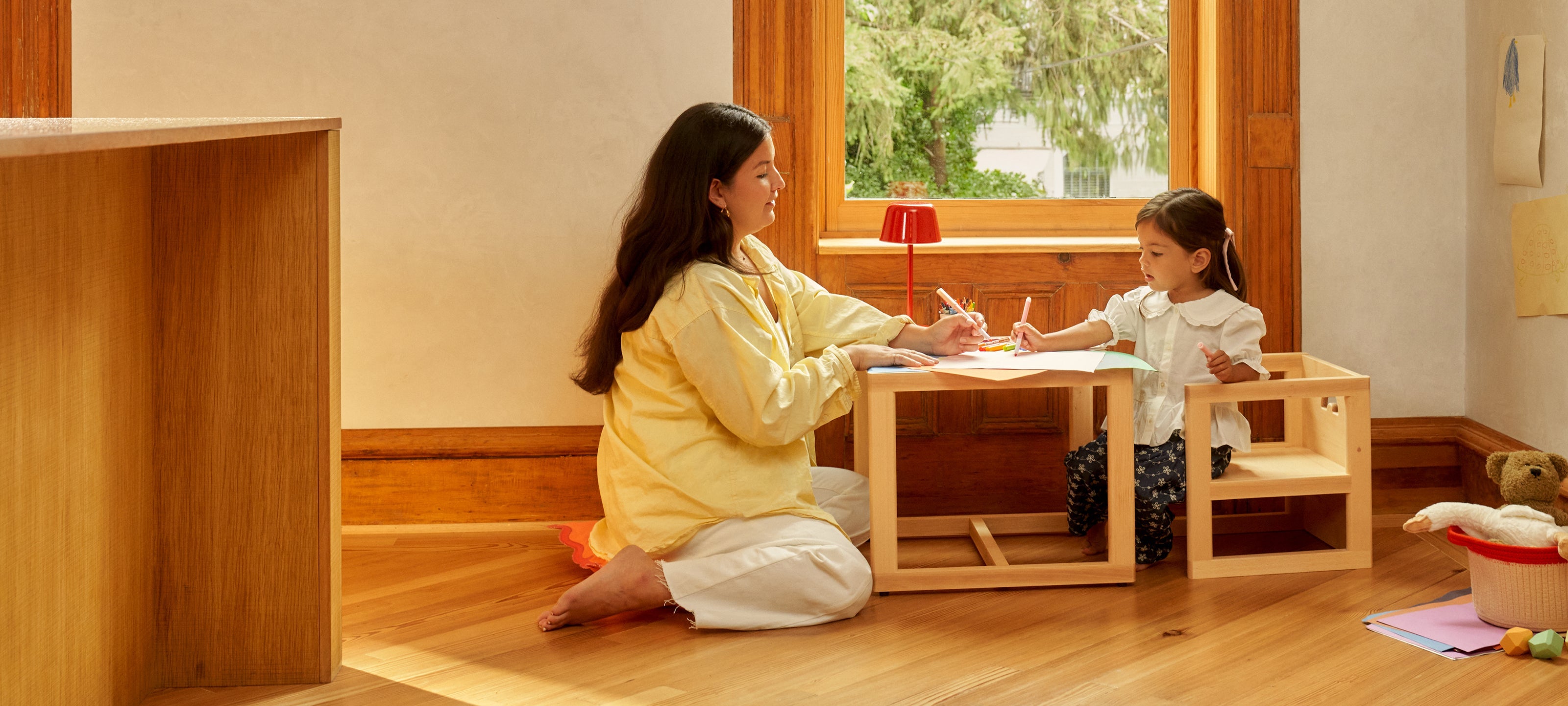 Piccalio kids table and chair set in natural wood with a mother and toddler daughter drawing together.