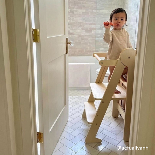 Child using foldable helper stool to brush their teeth