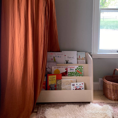 Child's bedroom with a Montessori bookshelf featuring 3 tiers and front-facing shelves for early literacy.