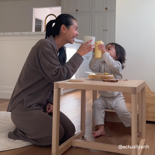 Toddler eats at the Piccalio Montessori weaning table and chair set with mother beside