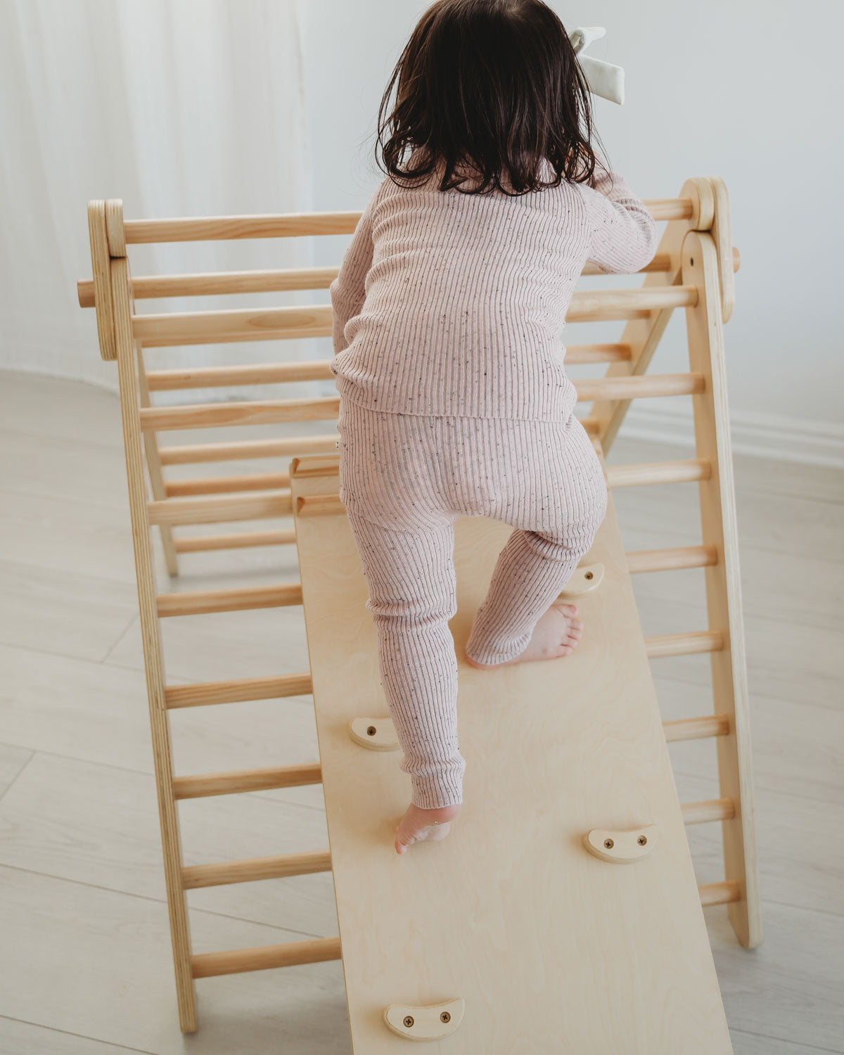 toddler girl climbing on montessori toys