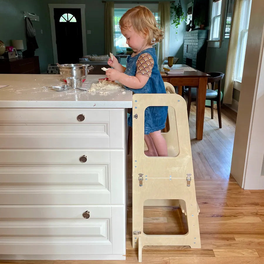 18 mo old toddler on piccalio convertible toddler tower in kitchen