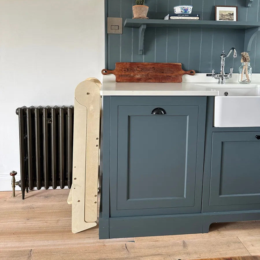 piccalio foldable toddler tower folded and stored away while not in use in the kitchen