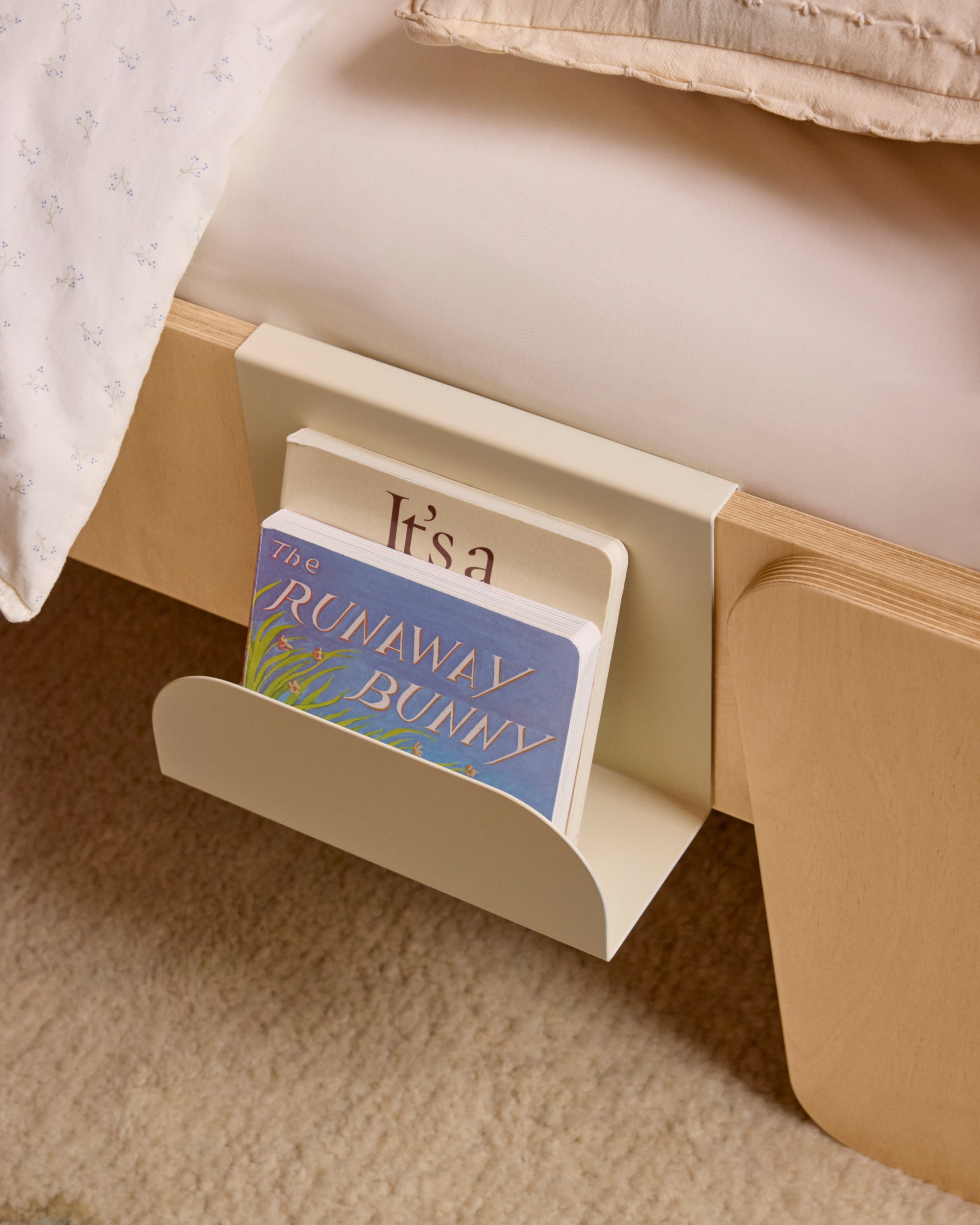 Piccalio bed book hook from metal in cream color attached to a Piccalio Montessori bed.