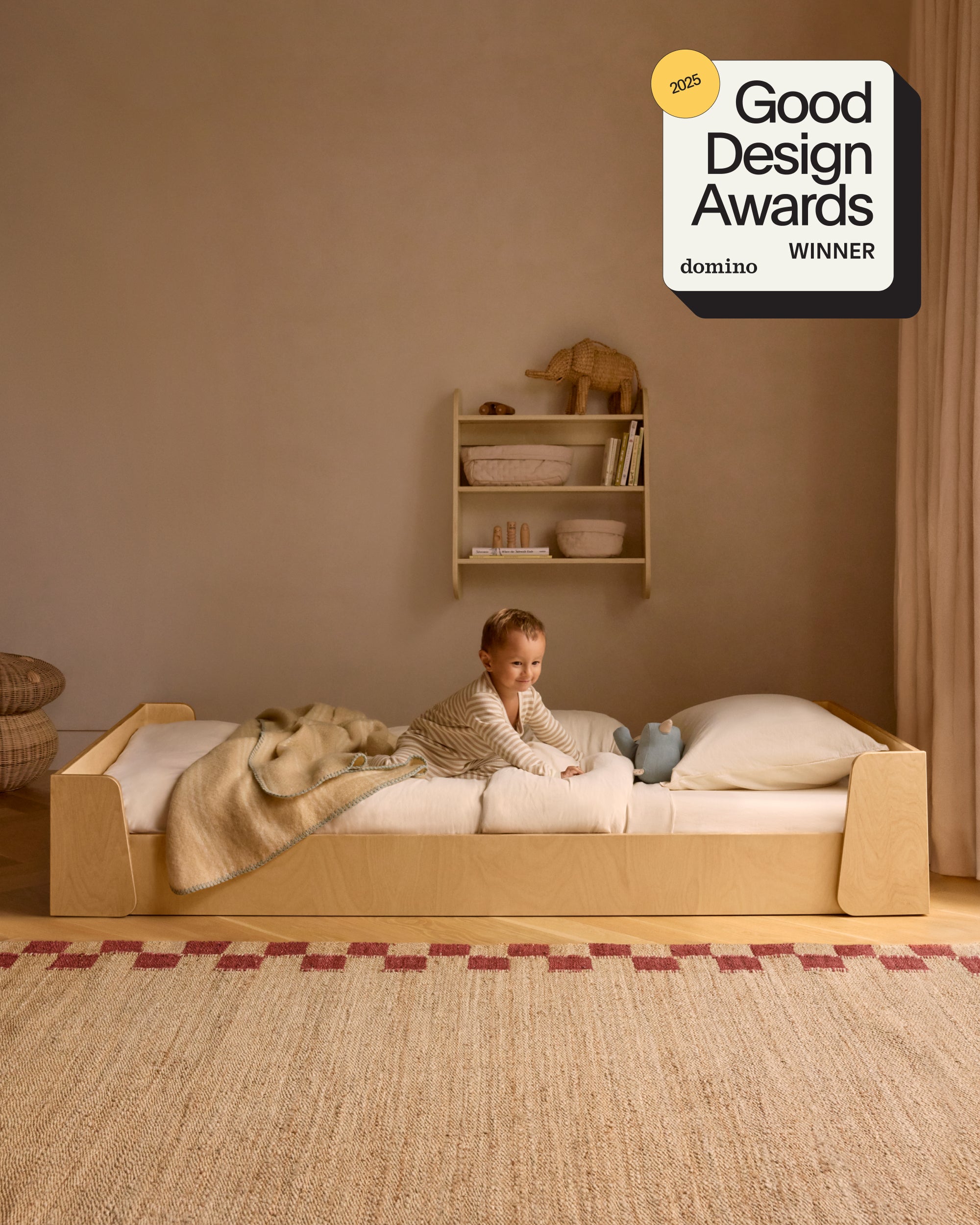 Piccalio Montessori bed in natural wood twin size with a child lying in the bed.