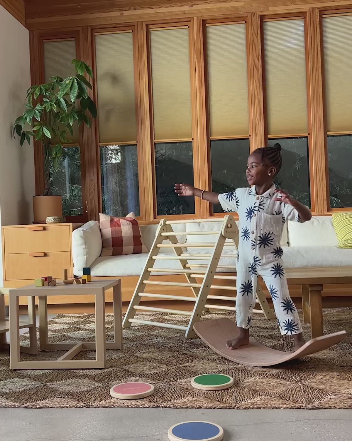Kids rock, balance, and lie on the Piccalio Surfer Balance Board — a curved wooden balance board for kids that supports gross motor skills, coordination, and open-ended Montessori play.