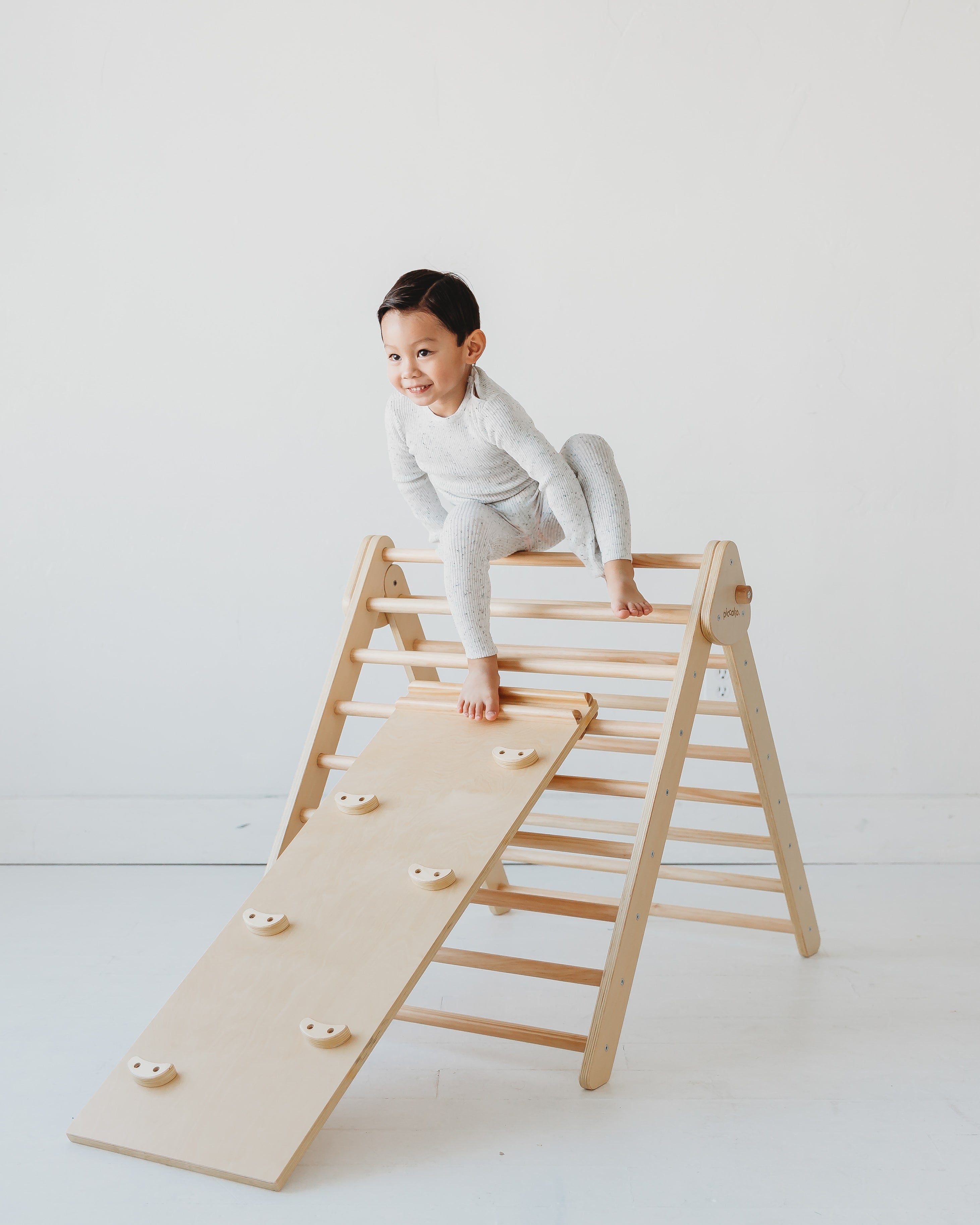 Toddler on a Piccalio Montessori climbing toy